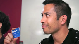 An employee holding a credit card with Facebook logo