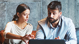 Two people working together at a laptop