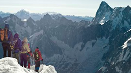 Mountain climbers looking towards a peak in the snow